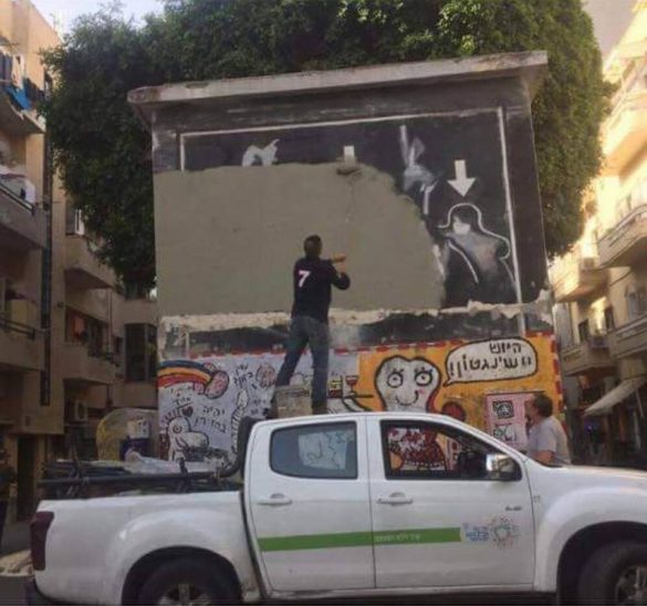 A municipality worker erasing Yigal Shtayim's mural